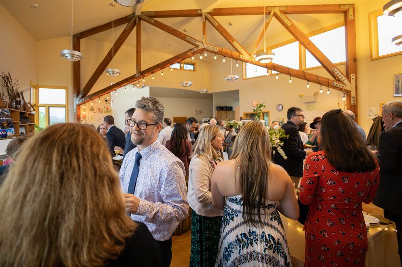 Vibrant scene at BeeBash with guests laughing and mingling, highlighted by festive decorations and dynamic lighting.